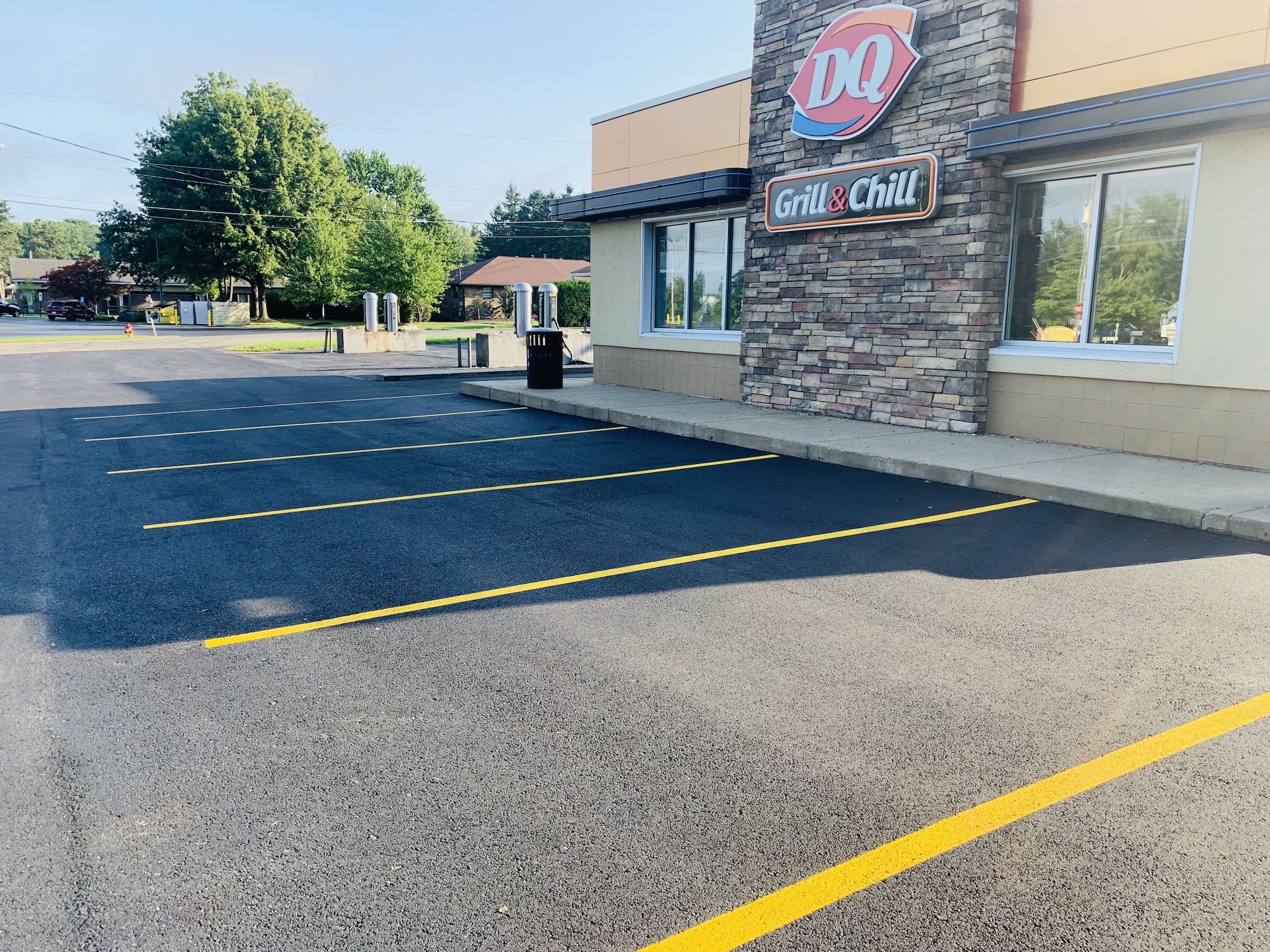 A freshly paved and painted parking lot in front of a dairy queen