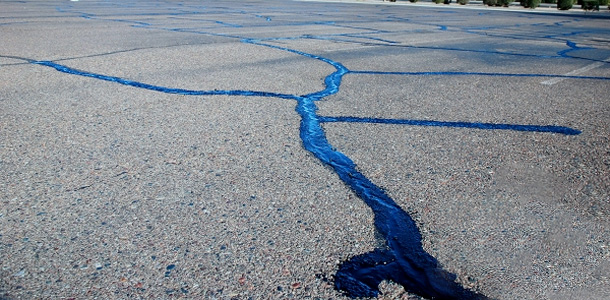 Cracks in a parking lot filled with asphalt