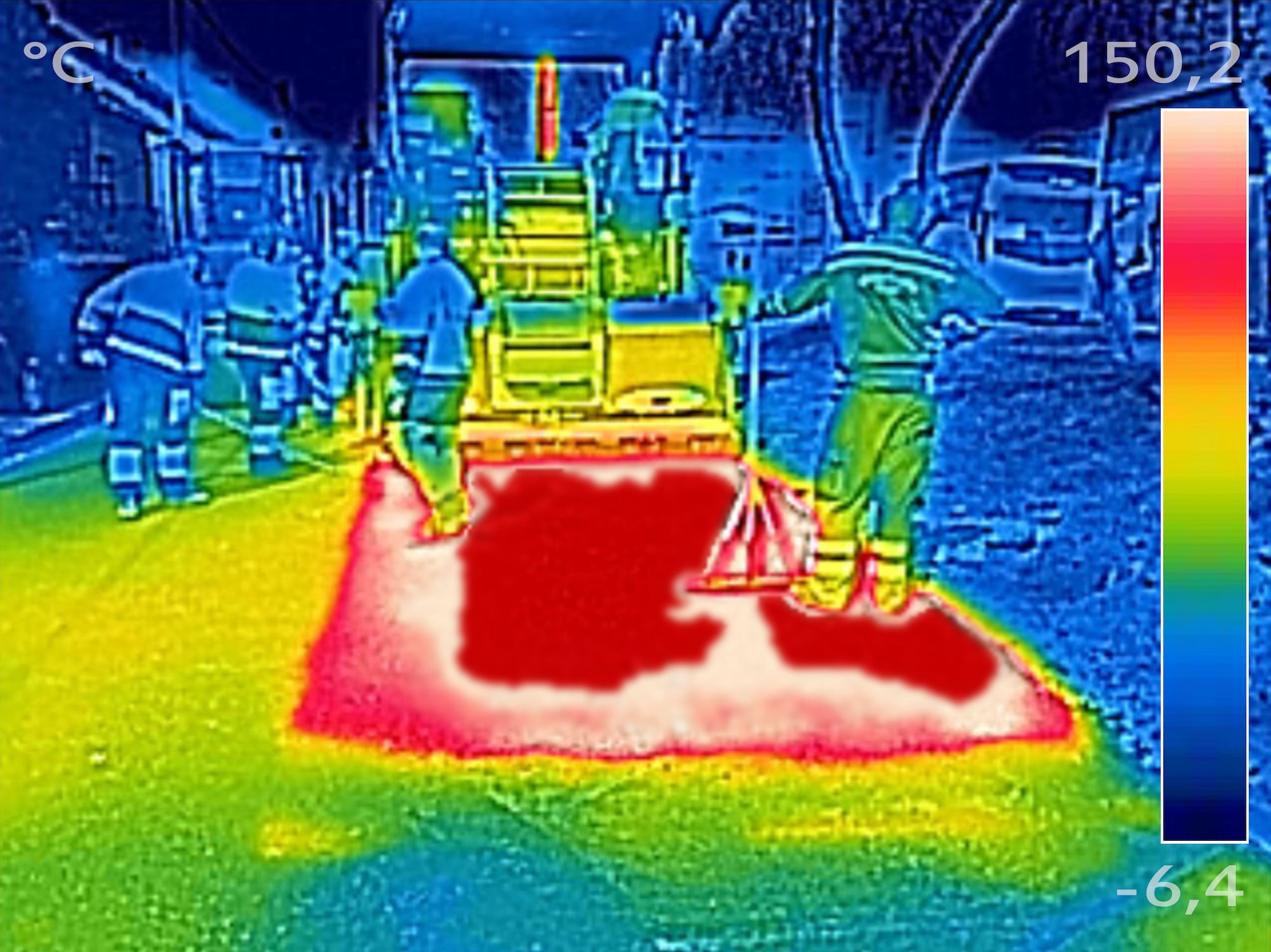 A thermal picture of workers paving a road with asphalt